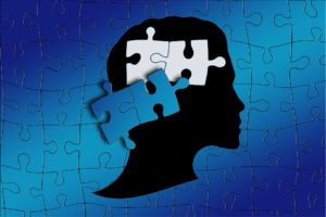 blue puzzle pieces with silhouette of head